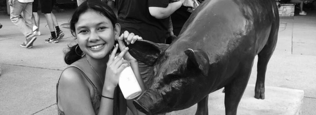 Sarah Jamil at the Iowa State Fair with a statue of a pig.